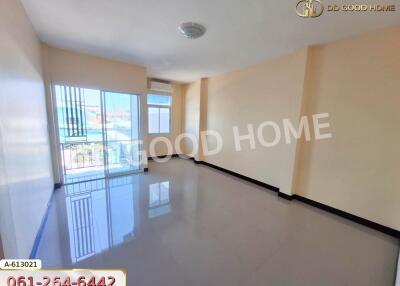 Spacious living room with large windows and tile flooring