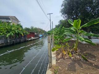 canal view with greenery and a fence