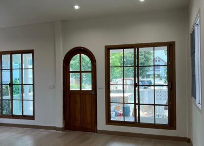 Spacious living room with large windows and wooden door