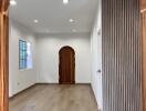 spacious living room with wooden flooring and arched doorway