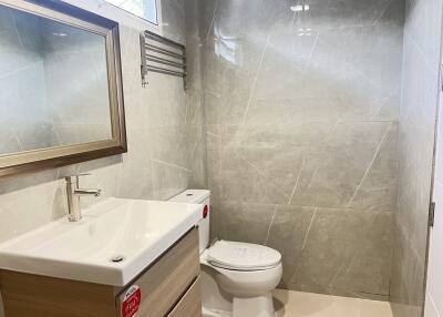 Modern bathroom with sleek gray tiles, mirror, and vanity