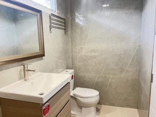 Modern bathroom with sleek gray tiles, mirror, and vanity