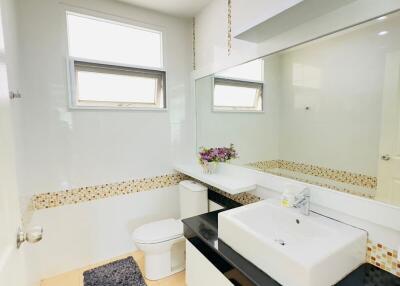 Modern bathroom with large mirror and white vanity