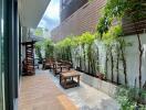 Modern outdoor patio with wooden seating and lush greenery