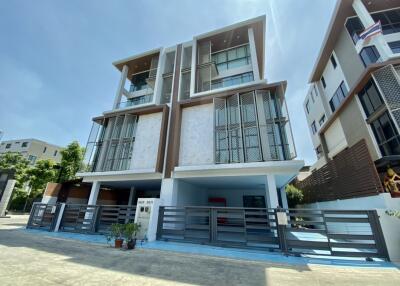 Modern three-story building with gated entrance and balconies