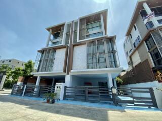 Modern three-story building with gated entrance and balconies