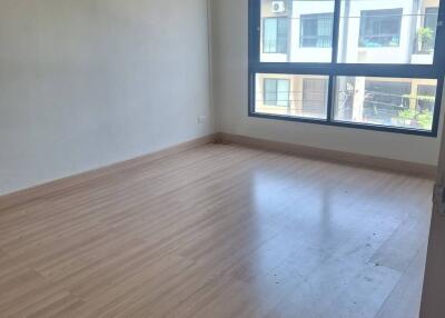 Empty bedroom with wooden floor and large window