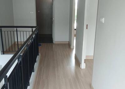 Bright hallway with wooden flooring and doors leading to different rooms