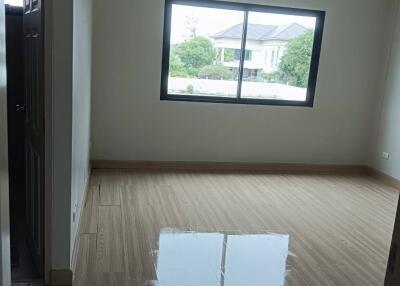 Empty bedroom with wooden flooring and large window