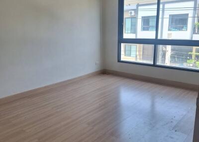 Empty bedroom with wooden flooring and large window