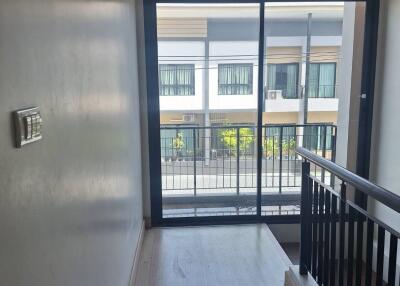 Upper floor hallway with a large window and balcony view