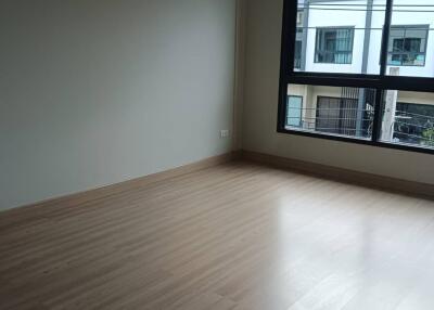 Empty bedroom with wooden flooring and large window