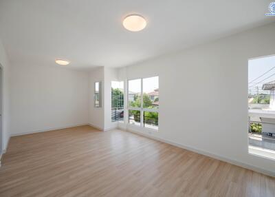 Spacious living room with large windows and wooden flooring