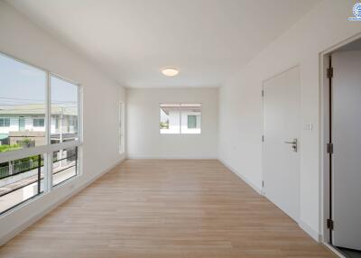 Empty room with large windows and wooden flooring