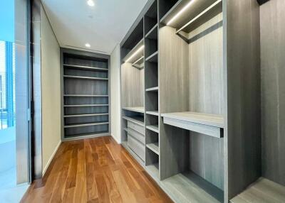 Spacious walk-in closet with wooden flooring and shelving