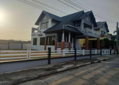 Exterior view of a house with a modern design and surrounding fence