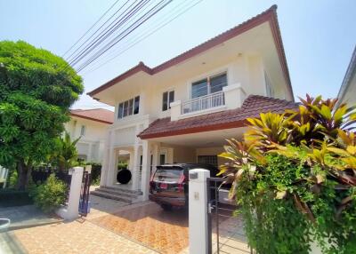 Front view of a two-story house with a driveway and greenery