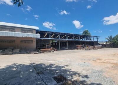 Outdoor area with large industrial building and surrounding yard