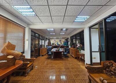 spacious office with wooden furniture and decorative ceiling tiles