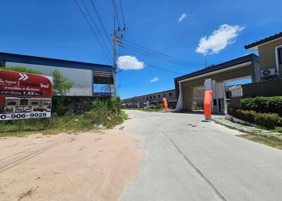 Entrance to a residential housing development with surrounding buildings