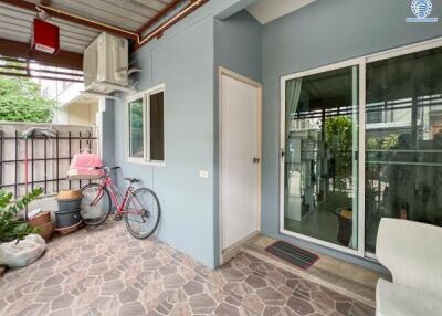 Outdoor patio area with bike, potted plants, and glass sliding door