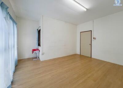 Spacious empty living room with wooden flooring and large windows