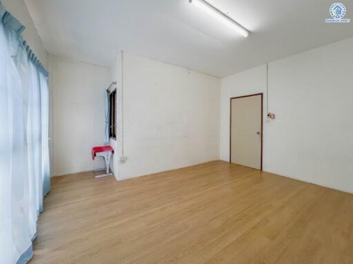 Spacious empty living room with wooden flooring and large windows