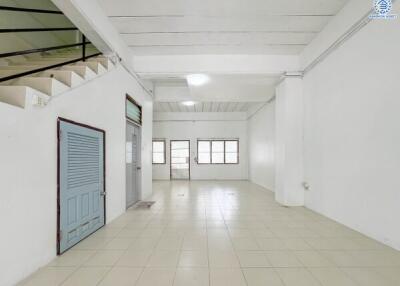 Spacious empty room with staircase and tiled floor