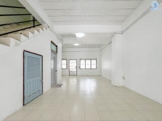 Spacious empty room with staircase and tiled floor