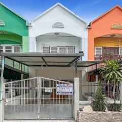 Front view of colorful row houses with a covered parking area and a gate