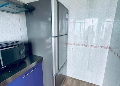 Small kitchen with stainless steel refrigerator and microwave