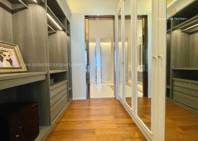 Spacious walk-in closet with mirrored doors and wooden flooring