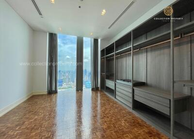 Spacious bedroom with large windows and built-in wardrobes