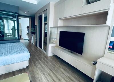 Modern bedroom with hardwood flooring, TV, and air conditioning unit