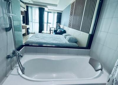 Bathroom with bath tub and view into bedroom
