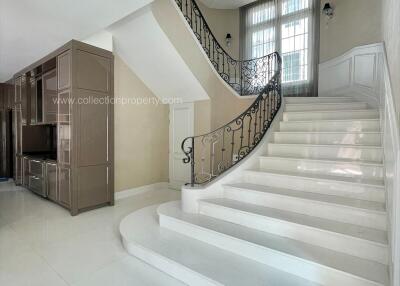 Spacious living area with a modern staircase and storage unit