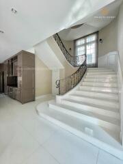 Spacious living area with a modern staircase and storage unit