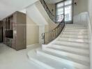 Spacious living area with a modern staircase and storage unit