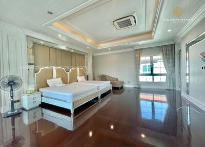 spacious master bedroom with two beds and large windows