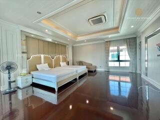 spacious master bedroom with two beds and large windows