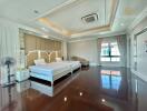 spacious master bedroom with two beds and large windows