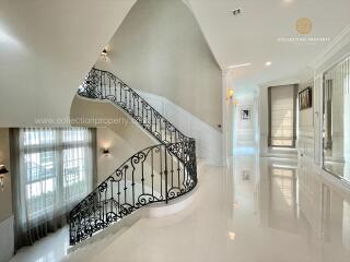 Elegant hallway with wrought iron staircase and large windows