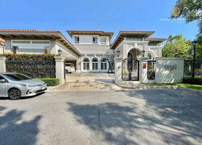 Exterior view of a large, luxurious residential building with a gated entrance