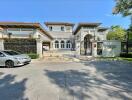 Exterior view of a large, luxurious residential building with a gated entrance