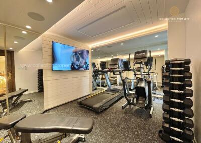 Modern fitness room with gym equipment and large mirror