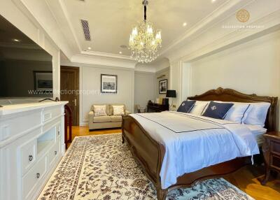 Luxurious master bedroom with chandelier and hardwood floors