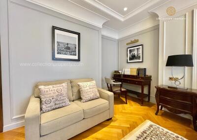 Cozy living room or study area with a sofa, books, art, and a desk