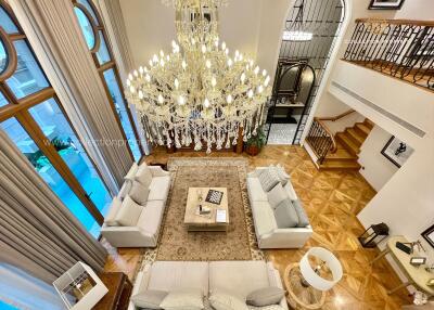 Luxurious living room with chandeliers, large windows, and comfortable seating