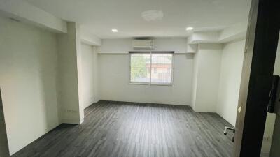 Empty bedroom with large window and air conditioning unit