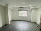 Empty bedroom with large window and air conditioning unit